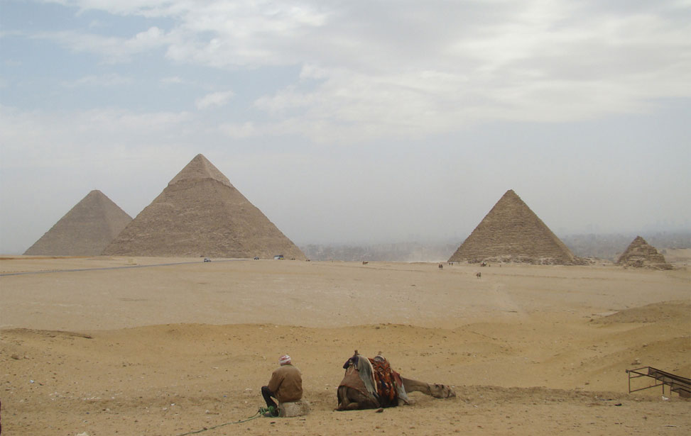 local man resting with camel near Giza Pyramids